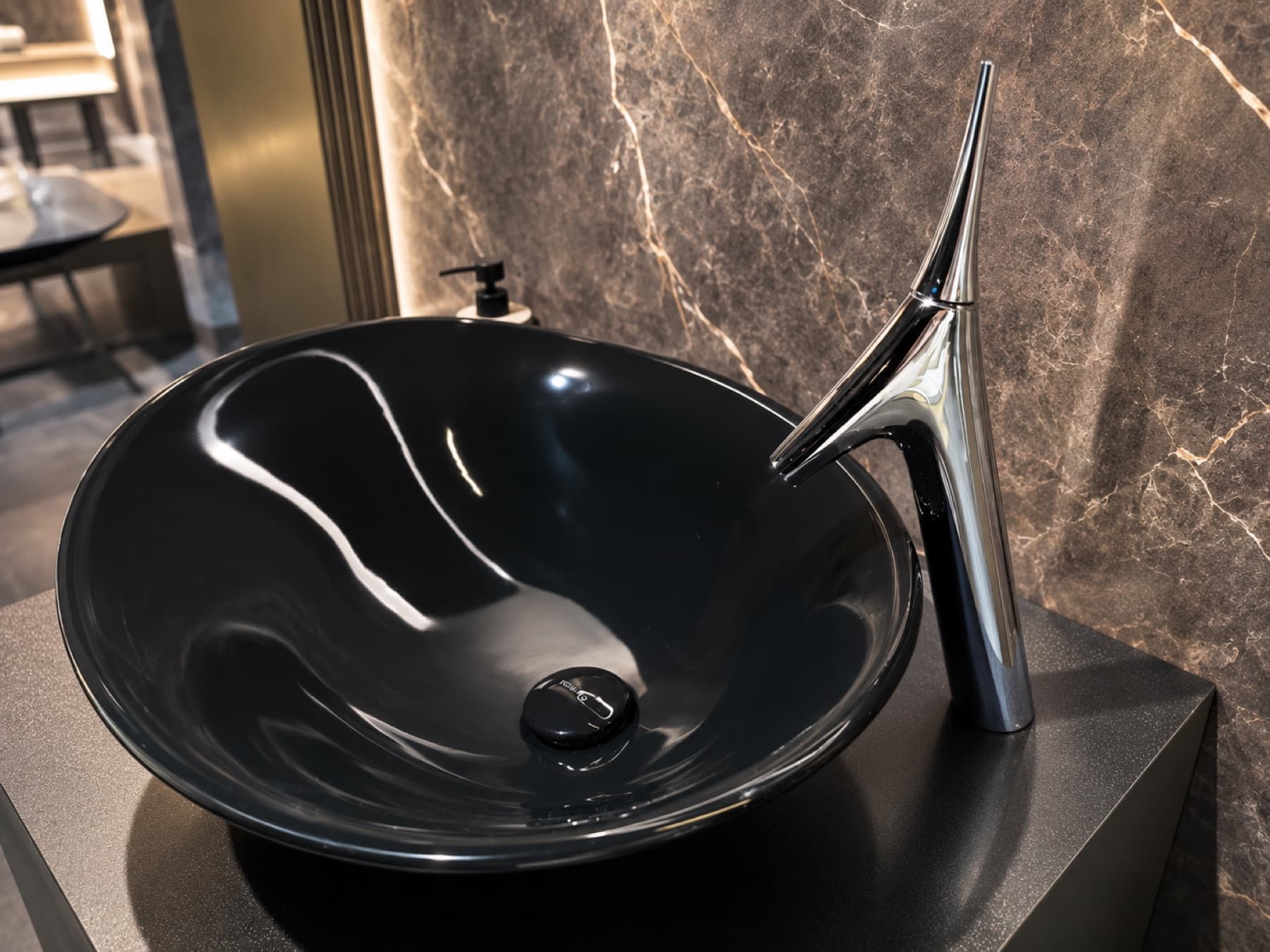 Sculptural Kohler vessel faucet in polished chrome with a black vessel basin at the Tayo Living Kohler showroom, Gurgaon